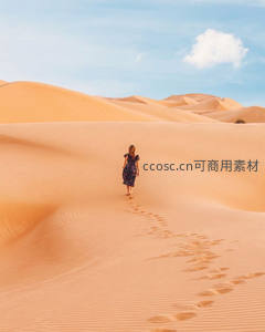 女子漫步于橘色沙丘留足迹