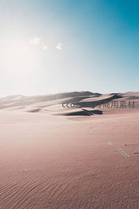 阳光下的粉色沙丘与蔚蓝天空