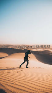 奔跑者剪影跃动沙海间