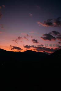群山剪影托晚霞，云卷云舒染天边
