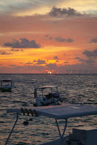 小舟漂浮碧波上，夕阳沉入海中央