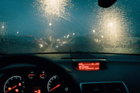 车窗雨滴折射夜光，仪表盘微光闪烁