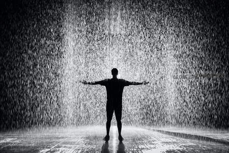 张开双臂拥抱倾盆大雨的人影