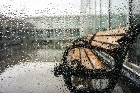 雨中窗前空荡长椅的寂寥景象