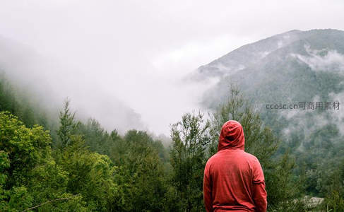 红衣旅人静立山巅俯瞰云海缭绕