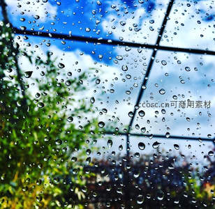 窗上雨珠折射蓝天绿树
