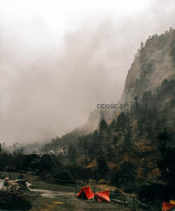 云雾缭绕山间营地，红色帐篷点缀苍翠
