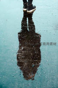 水洼倒影中的行人剪影