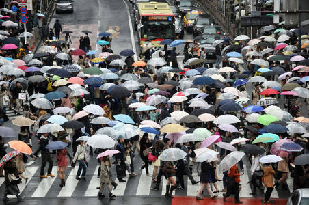 雨中繁忙十字路口，五彩伞海涌动如潮