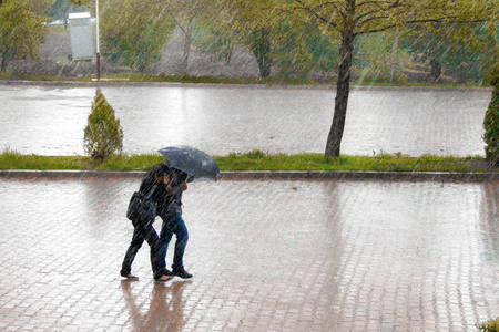暴雨中情侣共撑伞同行
