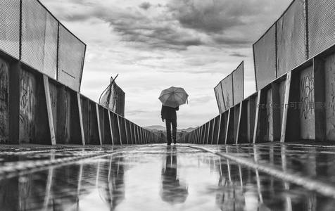 黑白雨中独行撑伞人影