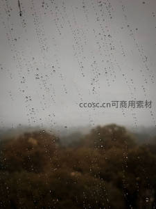 车窗雨滴滑落，远山朦胧如水墨