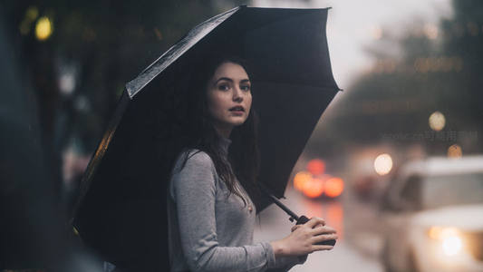 雨中女子撑伞凝望远方街景