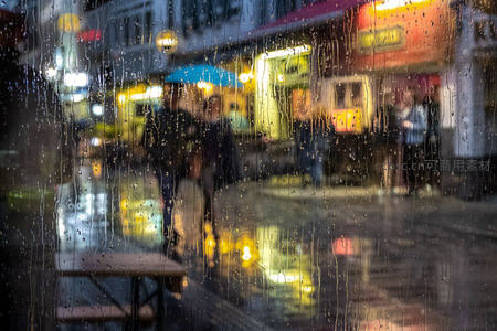 雨滴滑落玻璃，街景虚化如梦
