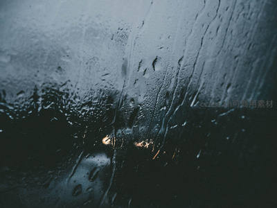 雨滴滑落窗玻璃映灯火