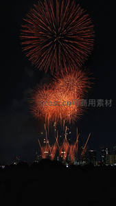 红色烟花照亮夜空，城市剪影为背景