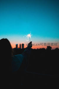 剪影少女举烟花迎日落