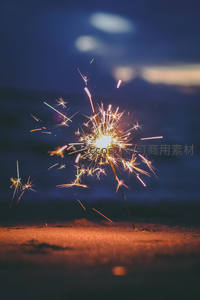 沙滩上的烟花棒照亮宁静夜晚