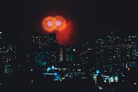 双朵橙红烟花如心形悬于都市夜空之上
