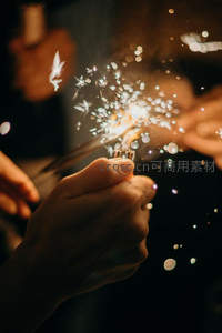 双手点燃烟花棒，庆祝时刻星光点点