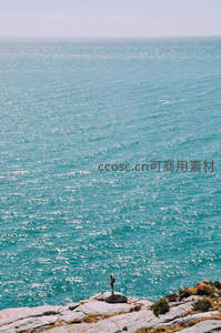孤影立崖边，俯瞰浩瀚蔚蓝大海
