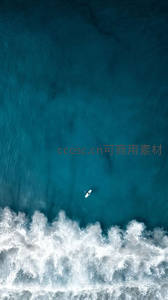 航拍视角下的冲浪者与海浪