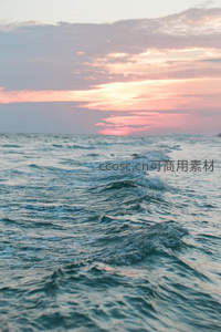 粉紫色晚霞下的无垠海面波纹