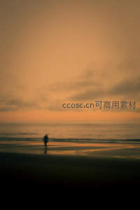 黄昏沙滩漫步，模糊人影与暖色天空