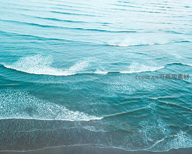 碧海浪花轻抚黑沙滩的航拍视角