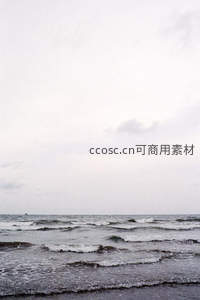 阴天海岸灰白浪花拍打礁石