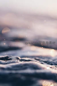 海浪泡沫在夕阳下闪烁微光