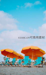 橙色遮阳伞与蓝色躺椅点缀沙滩