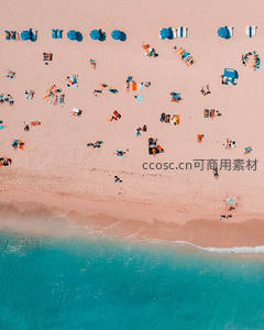 粉沙海滩上的蓝色遮阳伞与游客