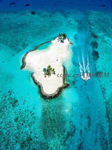 碧海白沙小岛与疾驰快艇的航拍美景