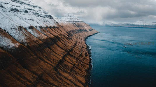 航拍雪山与深蓝海湾