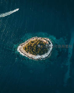 空中俯瞰圆形绿岛与快艇尾迹