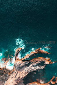 深蓝海浪拍打嶙峋礁石的壮丽航拍
