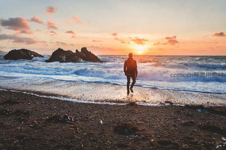 夕阳下孤独漫步海滩人影