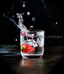 草莓坠入清水的动感瞬间