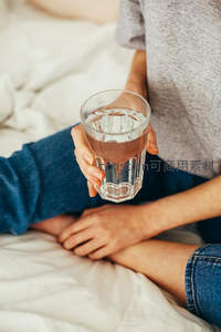 床上的人手握一杯清水