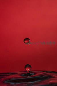 红色背景下的水滴悬停瞬间