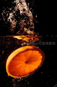 橙片入水瞬间，水花四溅光影绚烂