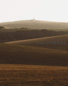 夕阳下山丘上的孤独建筑