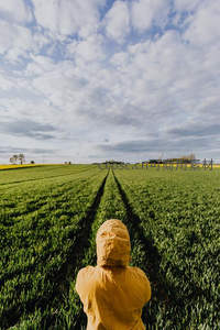 穿雨衣的孩子眺望田野