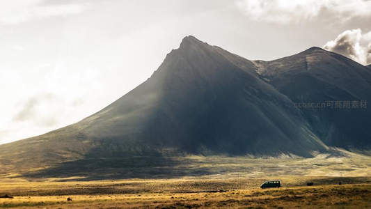 孤车穿行于雄伟山峦的旷野之间