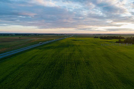 公路穿越绿野的黄昏航拍