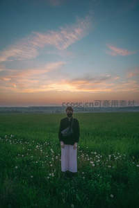 暮色花田中戴口罩的孤独身影