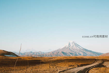 荒原土路延伸至雄伟雪山前