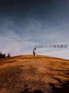 女子独行于广阔草原山顶