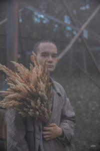 雾中男子手捧干枯芦花